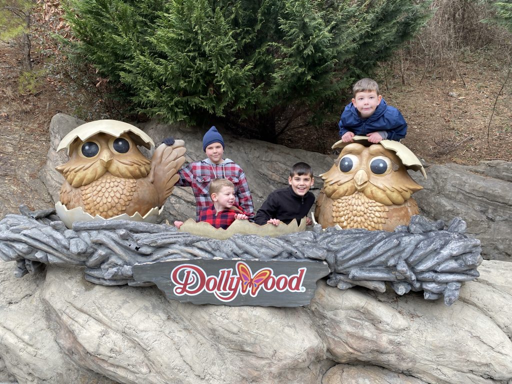 the author's four boys posing with a Dollywood sign