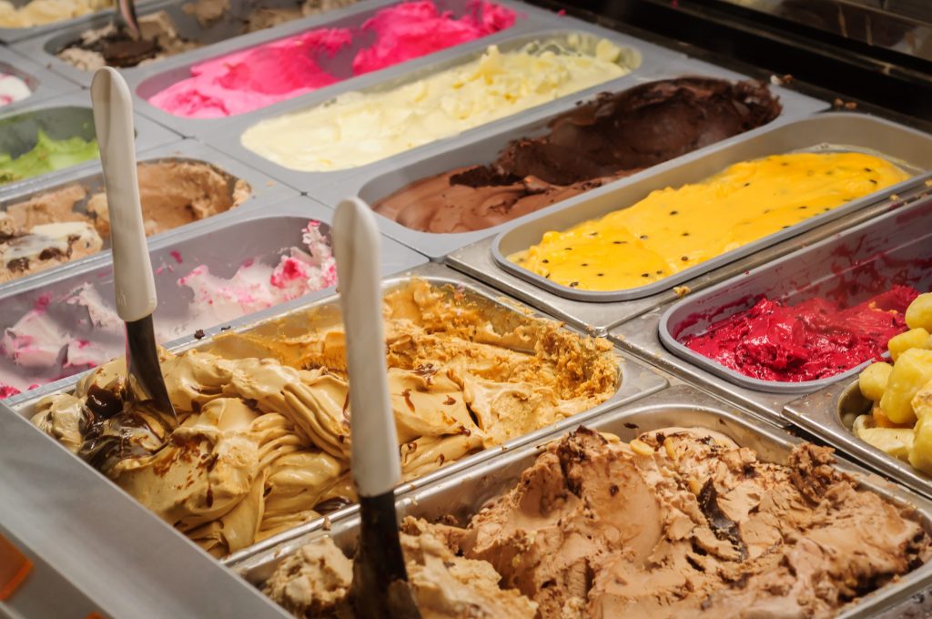 ice creams on display behind glass counter