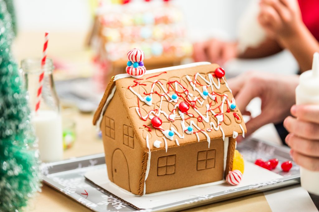 Kids decorating small gingerbread houses at the Christmas craft party.