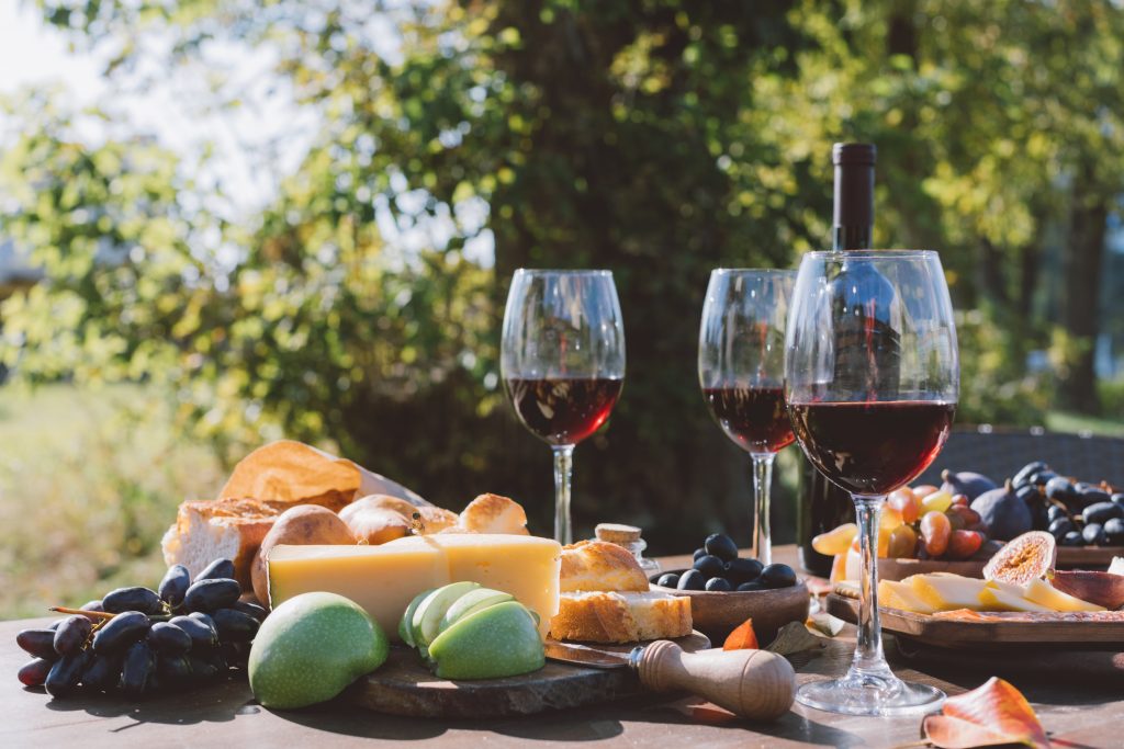 glasses of wine with cheese and fruit outdoors