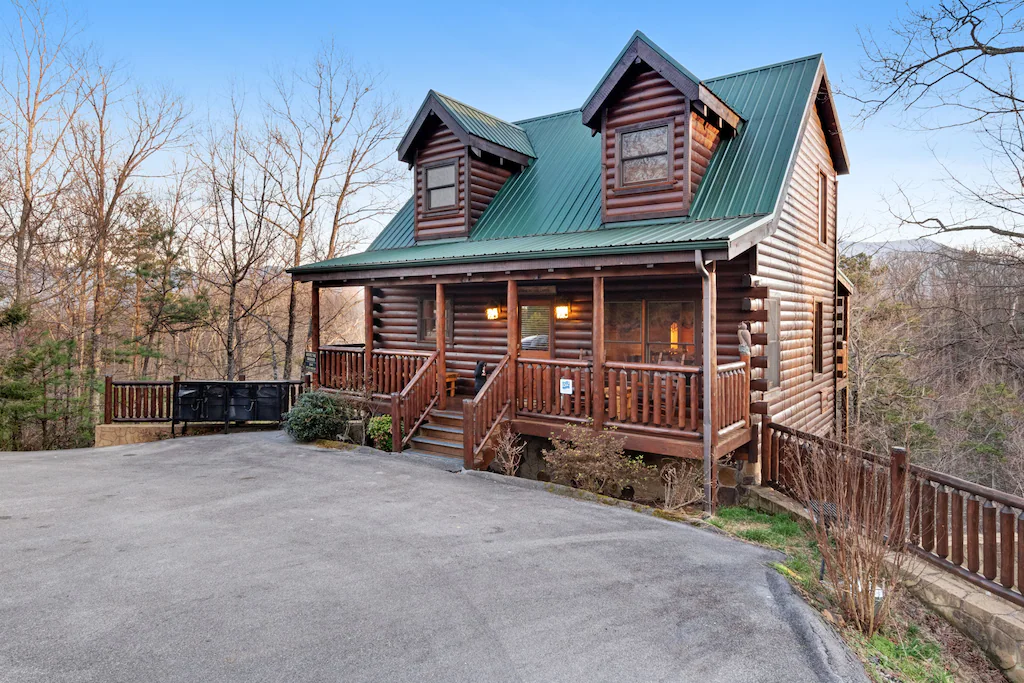 exterior view of log cabin with green tin roof