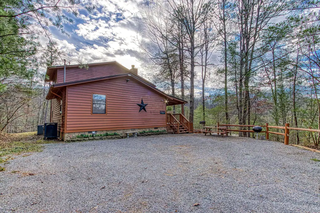 exterior view of mountain cabin with picnic table and grills