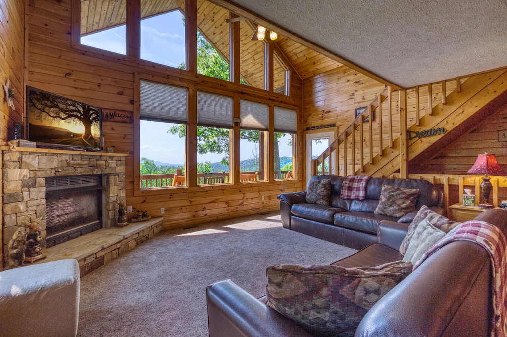 view of cabin living room with large windows and cathedral ceilings