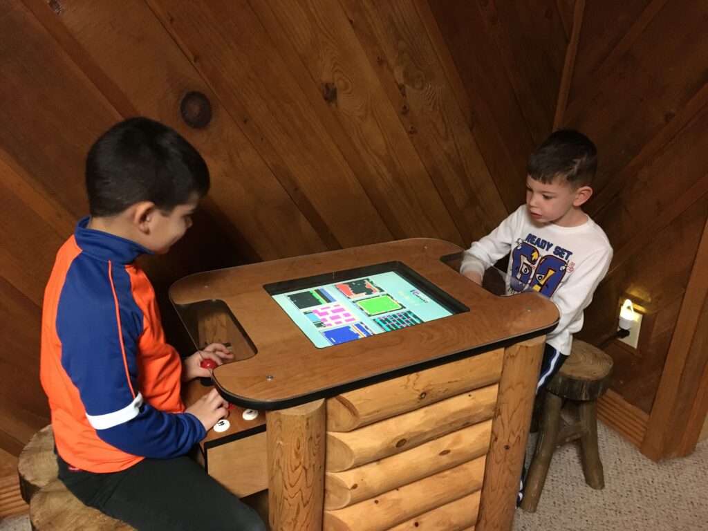 two of the author's sons playing an arcade game at a luxury Pigeon Forge cabin