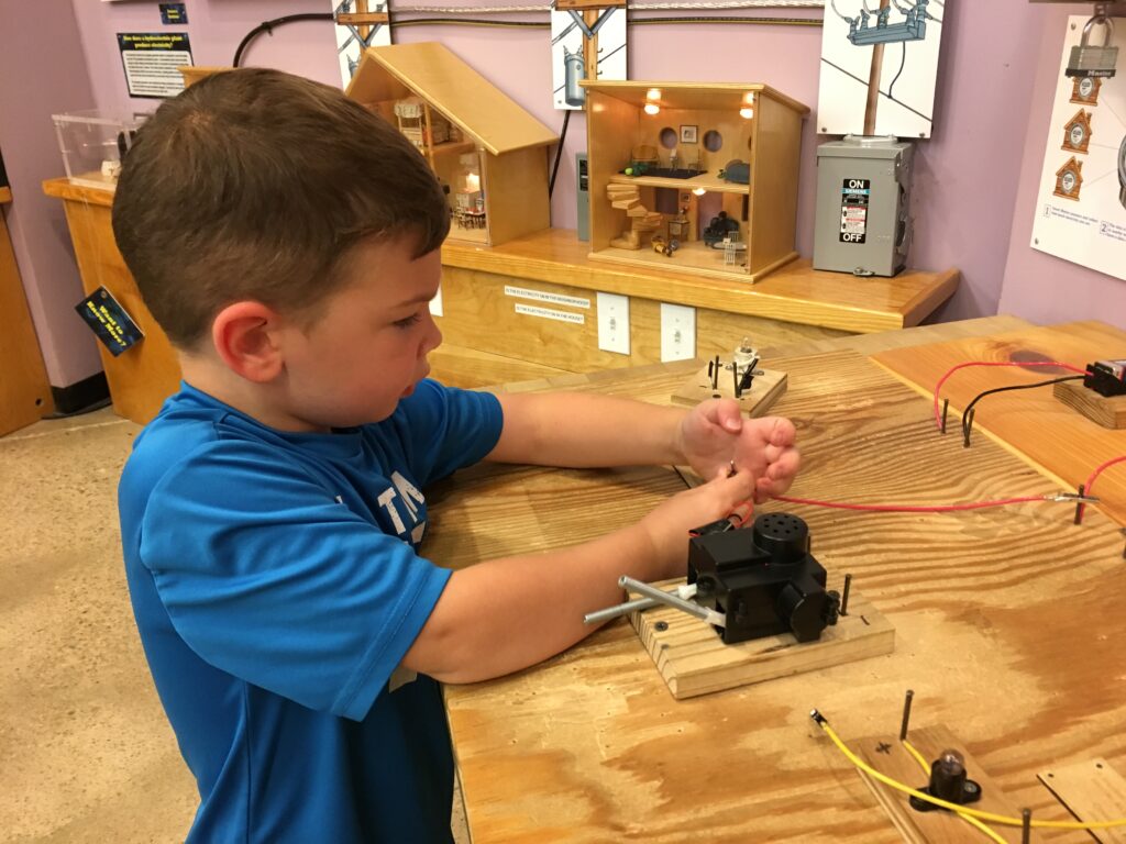 boy working on a hands-on exhibit at the Creative Discovery Museum in Chattanooga, TN