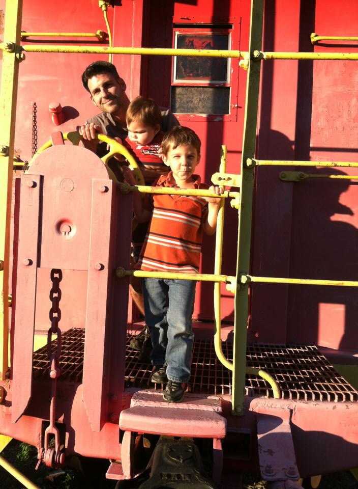 the author's husband and two sons on a train at the tennessee valley railroad musuem